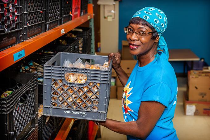 Woman Holding Crate of Food