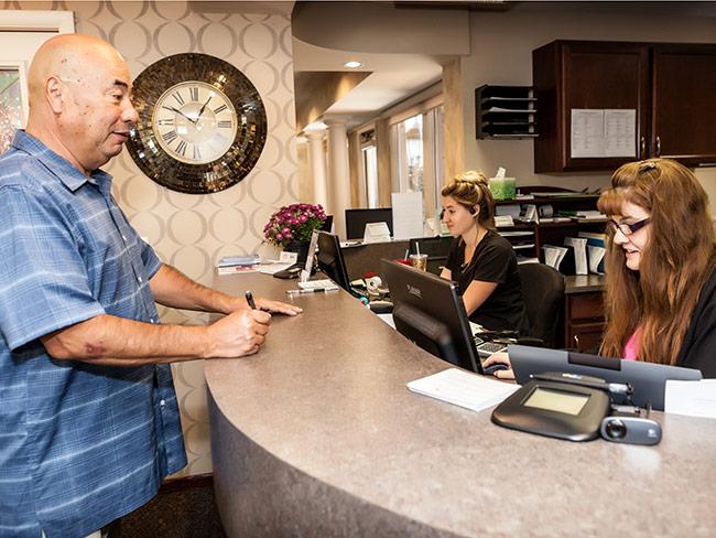 Patient Standing at Dental Office Counter